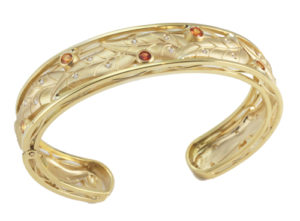 This elegant 18k yellow gold narrow cuff bracelet is adorned with graceful leaves and set with sapphires (1.40 ctw) and white brilliant diamonds (0.25 ctw) call for pricing (#440-00148)
