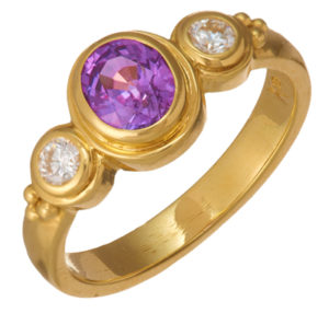 This classic 18k yellow gold ring is set with a 1.2 carat purple sapphire and two round brilliant diamonds. Call for pricing (#200-1759)

