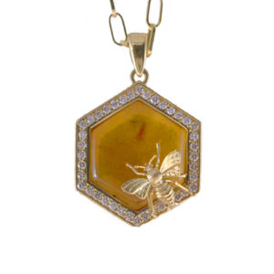 An 18k yellow gold bee sits atop this whimsical one-of a kind diamond (0.62 ctw) and amber pendant. The pendant is approximately 5/8″ in diameter. Call for pricing (#230-1575)

