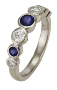 This 18k white gold band features 0.45 cwt. round brilliant diamonds and 0.54 cwt. of blue sapphires.  The stones are bezel set for classic perfection. Call for pricing (#120-0222)
