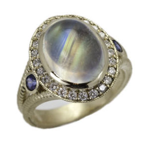 This 4.86 carat rainbow moonstone ring, set in 14k white gold, is surrounded by diamonds and blue sapphires. Call for pricing (#200-1601)

