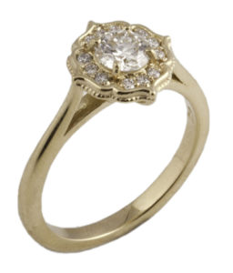 This lovely 18k yellow gold diamond flower ring is set with a half carat round brilliant diamond and is accented with 0.12 cwt. tiny round brilliant diamonds.  Call for pricing (#100-0395)
