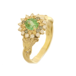 This 18k yellow gold flower ring features a green tourmaline (.71 ct) accented by diamonds (0.18 ctw G/SI) and sapphires (0.24 ctw). Even in the dead of winter, this flower stays in bloom. Call for pricing (#200-1927)